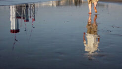 Timelapse footage of a man walking on the beach with Burj Al Arab building in the background