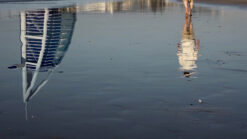Timelapse footage of a man walking on the beach with Burj Al Arab building in the background
